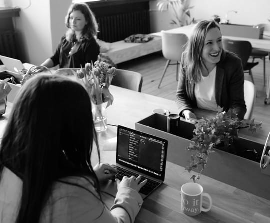 3 women happily working at computers